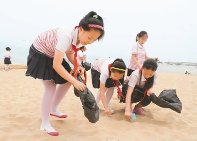 小学生在海边捡垃圾.