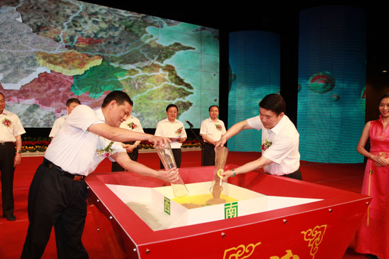 湖北省人民政府副秘书长骆新华、湖北省国土资源厅厅长孙亚将取自陕西的黄土倒入粮斗