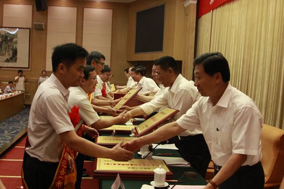 主席台就坐领导为获得模范县（市）和优秀组织奖单位代表颁发奖牌