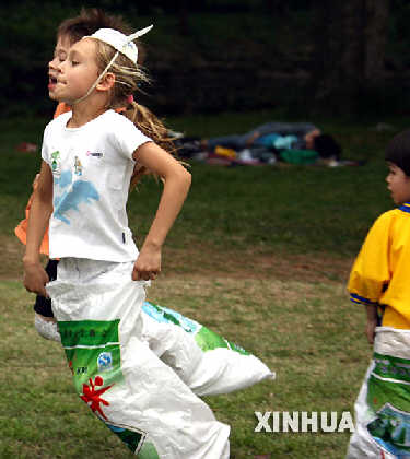 4月21日，两名儿童利用废弃的米袋在草地上奔跑做游戏。 &nbsp;&nbsp;&nbsp;&nbsp;4月21日，来自英、美、日、韩等国的百余个家庭的家长和孩子齐聚上海动物园，在搭建的国际民族村，展开环境保护、生物多样性保护等活动，呼吁人们携手保护地球家园。4月22日是世界地球日。 新华社记者　张明摄　